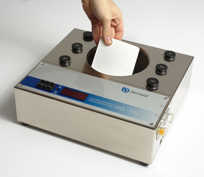 a chart-recorder disc being placed into the large CH132 chamber of the HG-101 for calibration